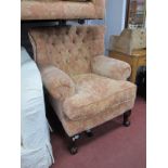 Armchair, with button back salmon pink floral fabric on cabriole legs, ball and claw feet.