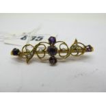 A 9ct Gold Amethyst Set Bar Brooch, of scroll design, graduated claw set, applied to plain bar,