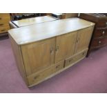 Ercol. Sideboard, with three cupboard doors over twin drawers, bow front base and top, 129cm wide.