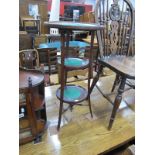 An Early XX Century Cake Stand, having three dish trays united by sabre legs, 69cm high.