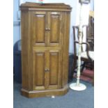 Oak Corner Cabinet, with twin panelled upper and lower doors and low gallery back, 133cm high.
