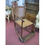 An Ealry XX Century Patient/Invalid Hospital Chair, cane seat and back, folding front foot rest