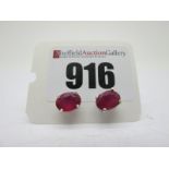 A Pair of Modern Single Stone Ruby Earstuds, oval four claw set, stamped "925".