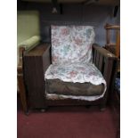 A 1930's Oak Recliner Easy Chair, with adjustable slatted back, left side fall table flap and