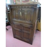 Oak Drinks Cabinet, with linenfold carving to fall front, over twin panelled doors, 80cm wide.