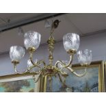 A Late XX Century Brass Chandelier, six branches supporting decorative ribbed glass shades.