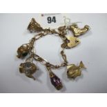 A 9ct Gold Fancy Link Bracelet, to 9ct gold heart shape padlock clasp, suspending six novelty