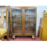 A 1930's Oak Display Cabinet, with low back, etched animal panels to twin astragal doors, on paw