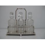 A Decorative Three Bottle Plated Tantalus, with high angular swing handle, raised on stepped feet,