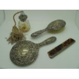 A Hallmarked Silver Backed Hair Brush, together with a mirror, comb and scent spray. (4)