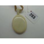 A Late Victorian Plain Oval Ivory Locket Pendant, with tapering fluted bail, on cream velvet