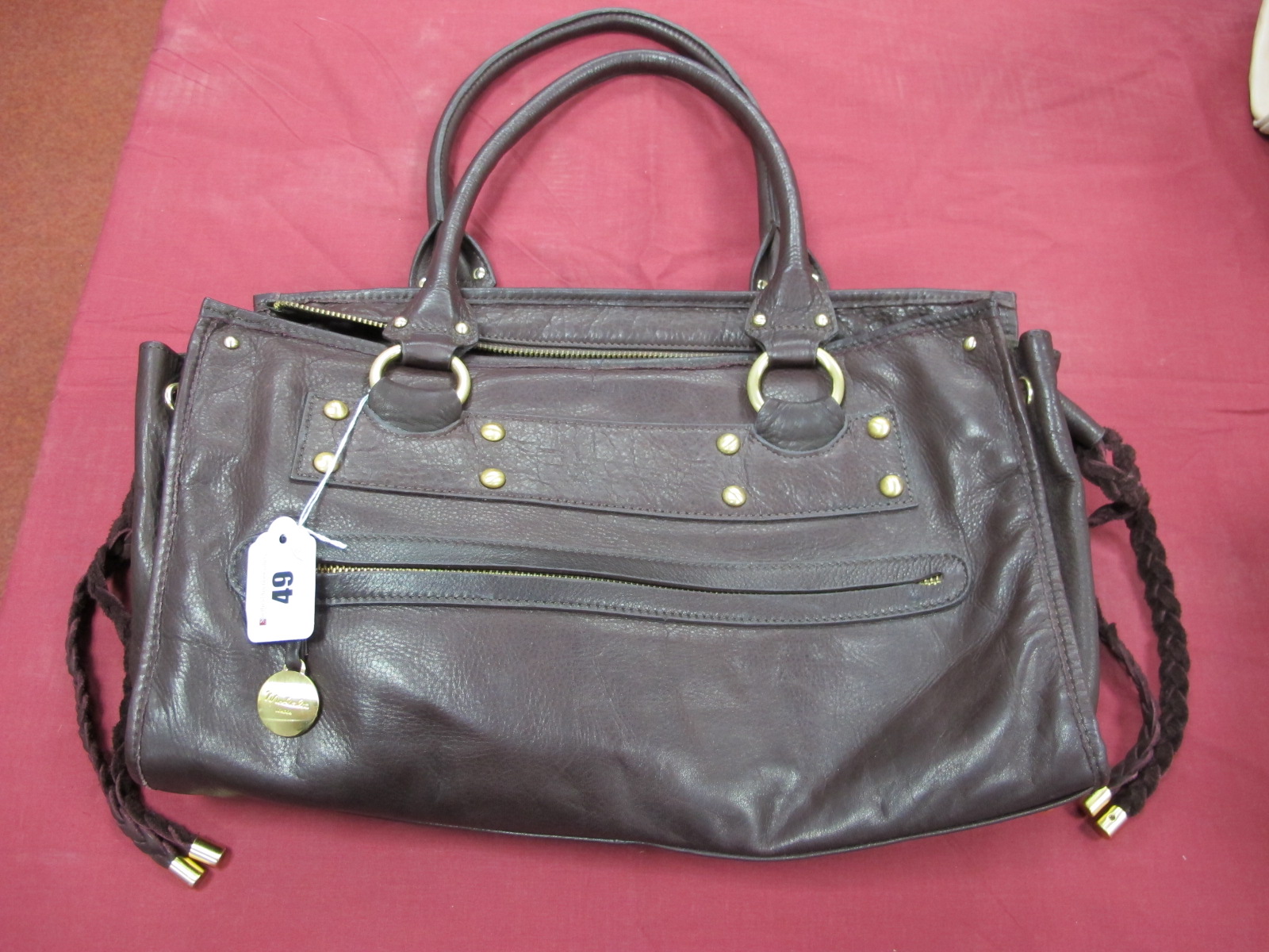 A Modalu Brown Leather Handbag, with satin brass stud detail, front zip pocket, twin rolled handles,