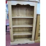 A Pine Bookcase, with moulded edge, reeded sides and three fixed shelves, on a shaped plinth base,