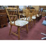 A Set of Four Spindle Back Kitchen Chairs, with curved arms and splayed legs.