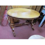 A XIX Century Mahogany Oval Topped Table, with turned pedestals on 'C' scroll feet united by