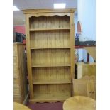 A Pine Bookcase, with stepped cornice, reeded sides and four open shelves, on a shaped plinth