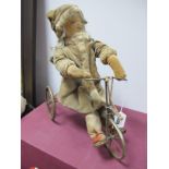 An Early XX Century Felt Doll on a Try-cycle, wearing fur trimmed winter outfit, 34cm/32cm long.
