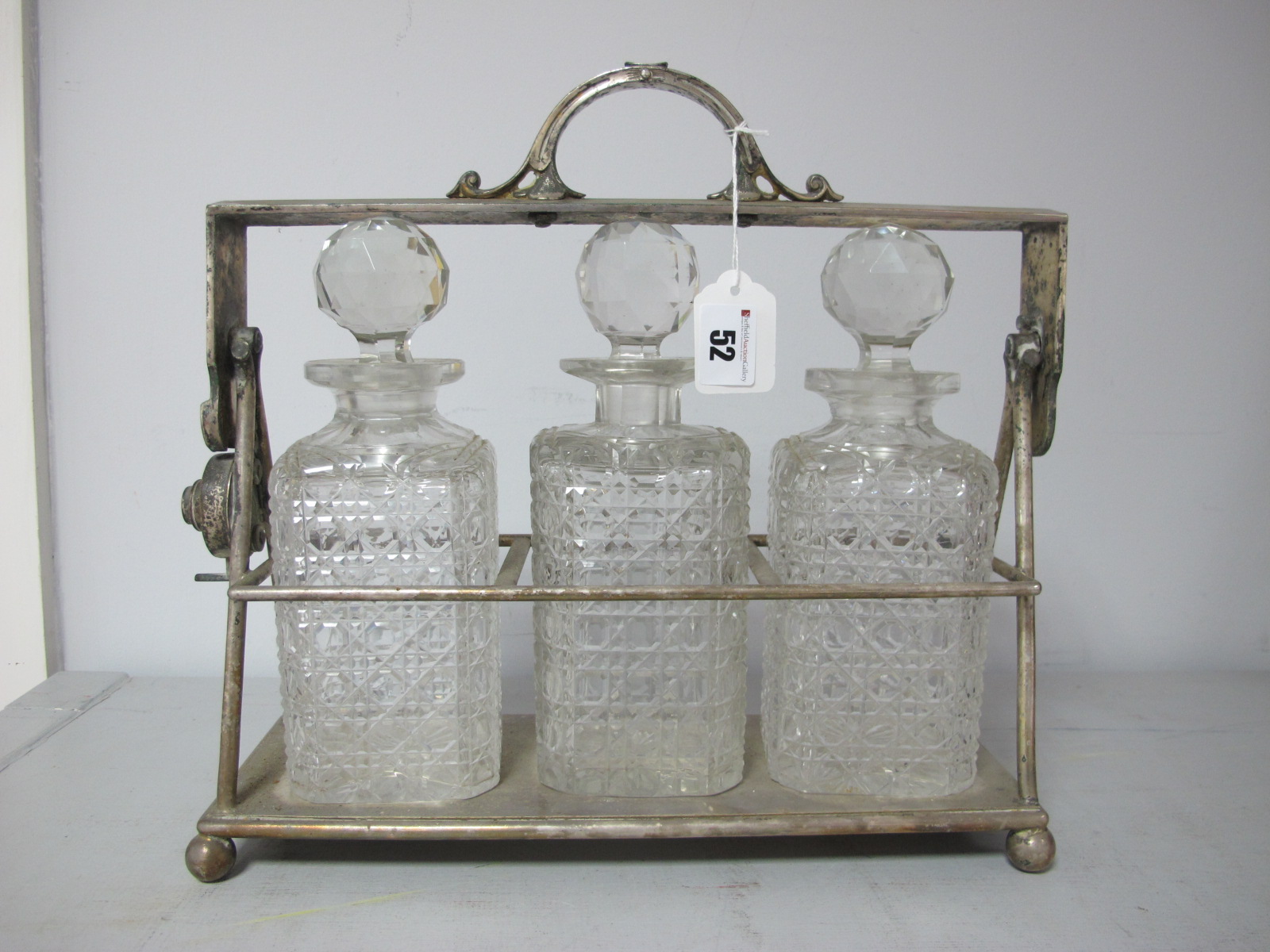 A JD&S Electroplated Three Bottle Locking Tantalus, of simple design, with three hobnail cut glass