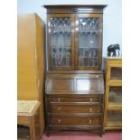 A 1920's Oak Bureau Bookcase, having stepped pediment, lead glazed astegral doors over fall font and