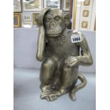 A cast Metal Figure of a Seated Monkey.
