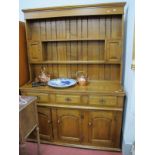 An Oak Dresser, having two small cupboards to planked rack, the base with three drawers over