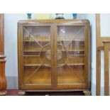 A 1930's Oak Display Cabinet, with astragal glazed doors, low back carved florets,and scrolled feet,