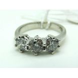 An 18ct White Gold Three Stone Diamond Ring, the brilliant cut stones claw set (finger size N).