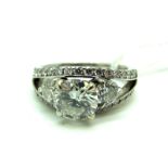 A Large Modern 18ct White Gold Three Stone Diamond Ring, high four claw set to the centre with a (