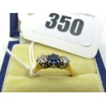 A Three Stone Diamond Set Ring, claw set, between plain shoulders, stamped "18ct" "Plat" (finger