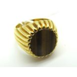 A Gent's Signet Style Ring, with inset oval hardstone panel, with allover reeded setting and