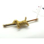 A Novelty Bar Brooch, the plain bar with applied dog, of textured finish, stamped "9ct", overall
