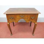 An XVIII Century Lowboy, the rectangular top with moulded edge, three small drawers, shaped apron,