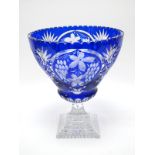 A Heavy Mid XX Century Blue Overlay Glass Pedestal Bowl, raised on a faceted stem and stepped square