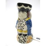 An Early XIX Century Prattware Toby Jug, in typical form wearing a blue jacket, spotted waistcoat,