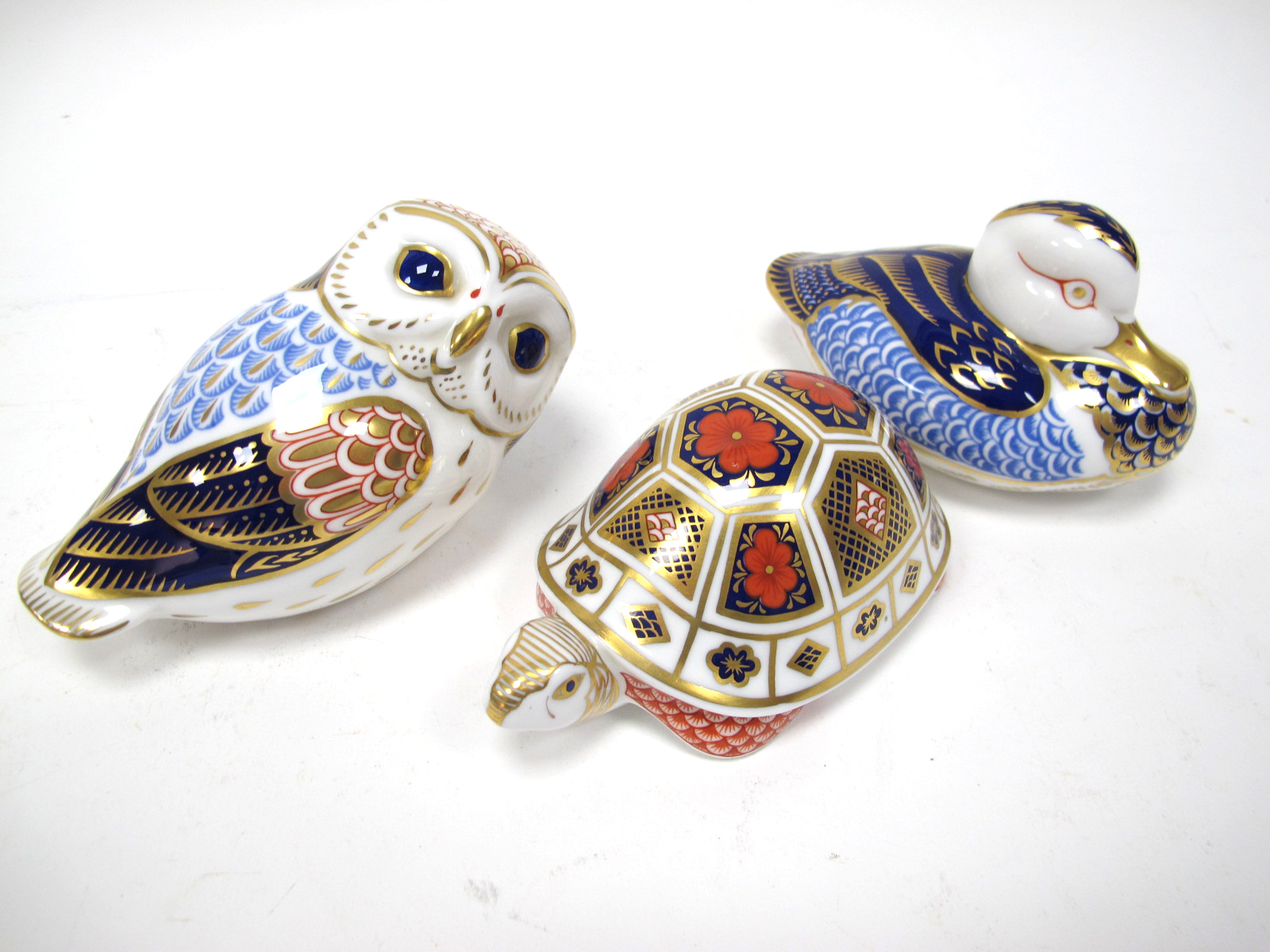 A Royal Crown Derby Paperweight 'Owl', gold stopper, 13cm long; A Further Two Paperweights, '