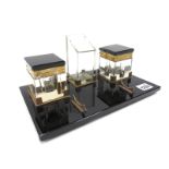 A 1930's Art Deco Desk Standish, the polished black glass base with a central pen holder, a pair