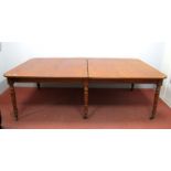 A XIX Century Regency Style Dining Table, with rectangular top, on turned legs with brass castors,