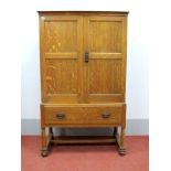 An Early XX Century Oak Linen Press, with a stepped cornice, twin panelled doors, three internal