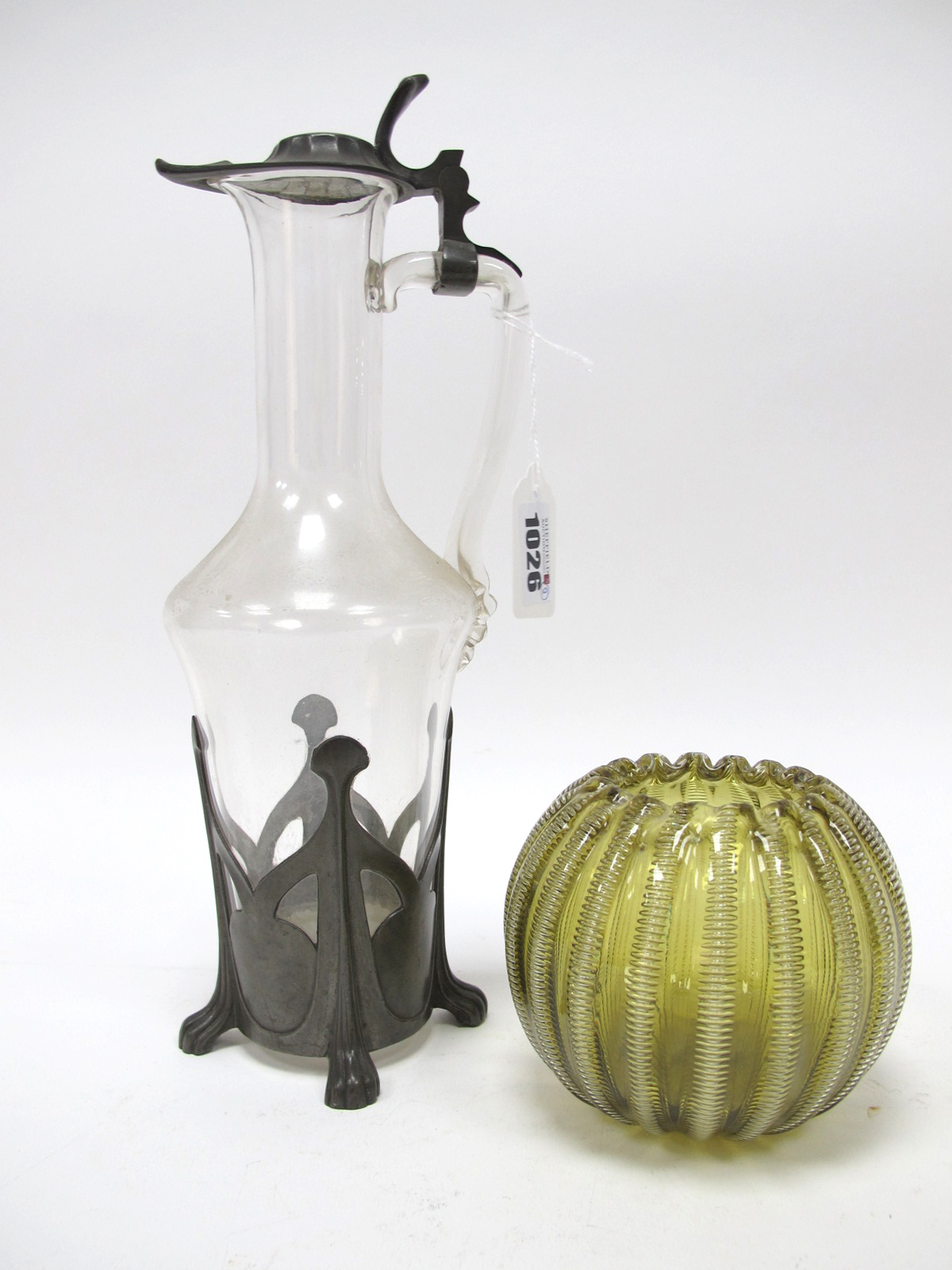 An Art Nouveau Glass Claret Jug, with pewter cover and base, pierced with stylised motifs, 30cm