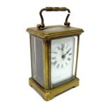 A French Brass Cased Carriage Clock, the white enamel dial with Roman numerals, the back plate