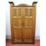 An Early XX Century Johnson and Appleyards Ltd Oak Wardrobe, the top with half round back, the
