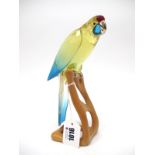 A Swarovski Crystal Paradise Bird Sculpture 'Green Rosella', on naturalistic wooden branch, 20.6cm