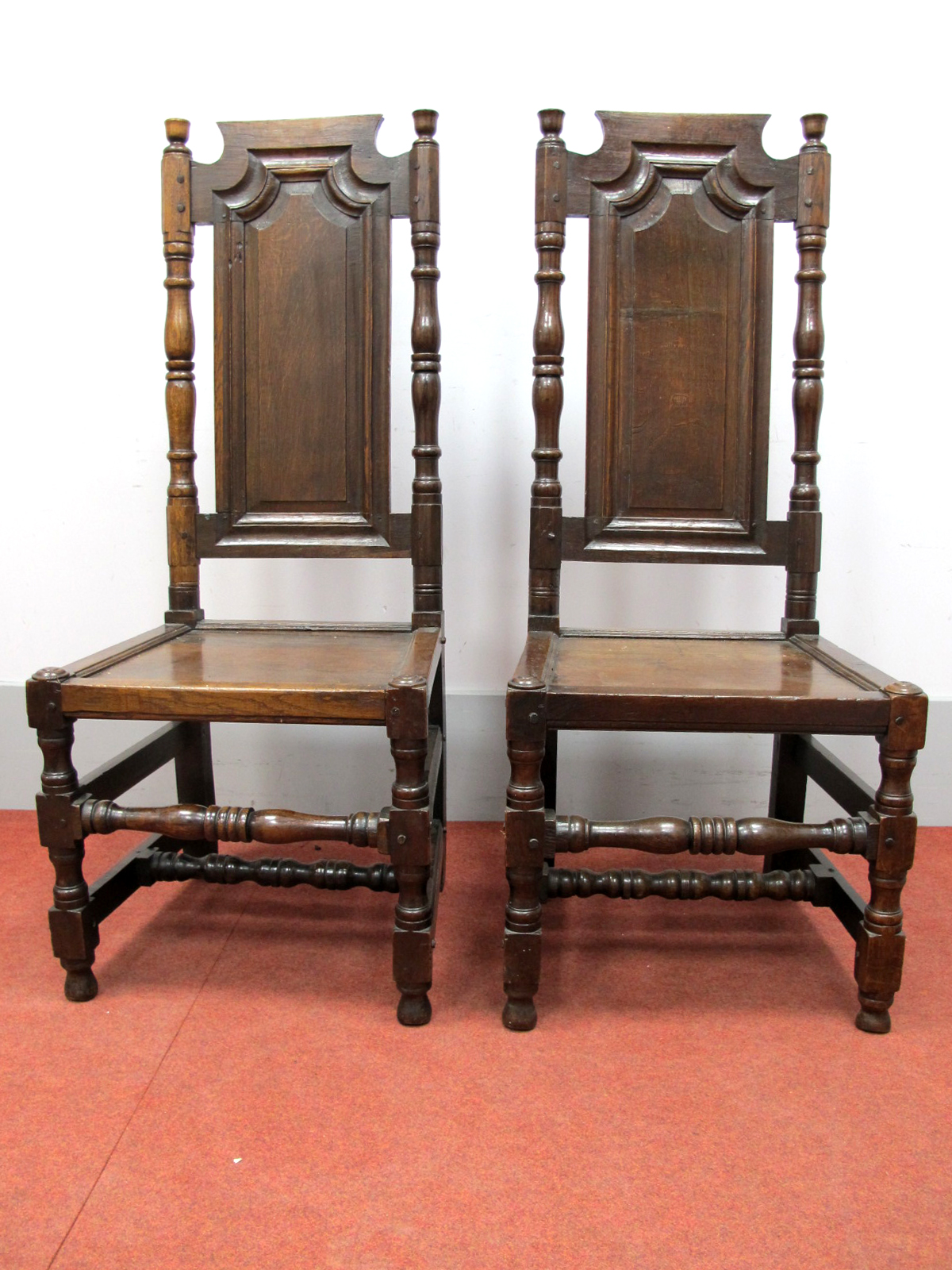 A Pair of XVII Century and Later Joined Oak Chairs, with flat top rails, turned finials, arched