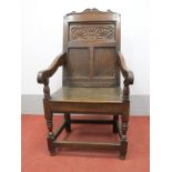 A XVII Century Joined Oak Wainscot Chair, with a shaped top rail, panelled back, shaped arms,