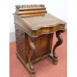 A Mid XIX Century Walnut Davenport, with a pierced three-quarter gallery, fitted interior, shaped