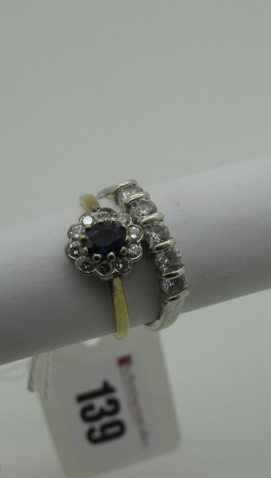 An 9ct Gold Sapphire and Diamond Cluster Dress Ring, oval claw set to the centre within border of