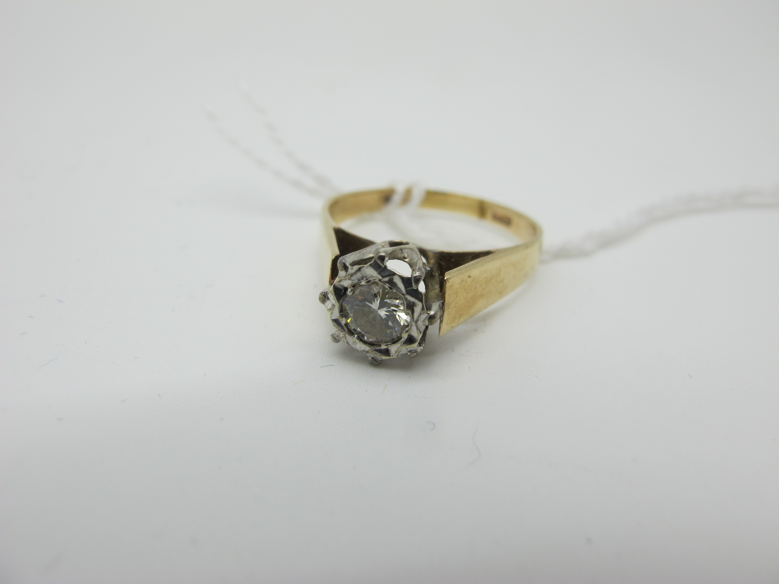 A Single Stone Diamond Ring, the brilliant cut stone illusion set high between plain tapering