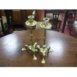 A Pair of XIX Century Brass Candlesticks, raised on a shaped fluted column and three pad feet.