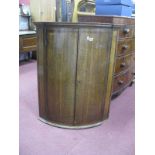 A Georgian Period Oak and Mahogany Crossbanded Corner Cupboard, with cylinder fronted twin doors and