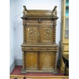 A Late XIX Century Carved Oak Cabinet, the top with twin panelled doors with applied carvings, the